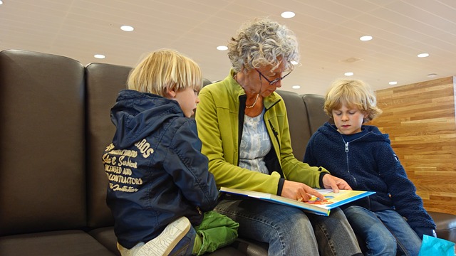 Een oudere vrouw leest voor aan twee kinderen.